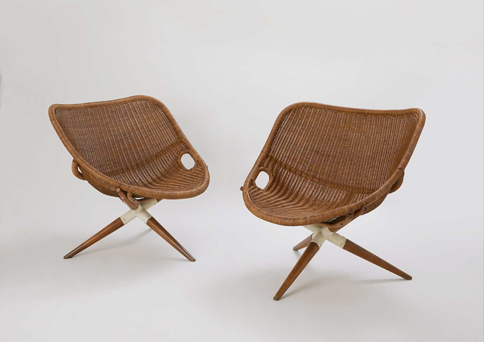 Joseph-André Motte, fauteuil Tripode, conçu en 1949. La coque tressée, les poignées et le piètement en bois sont visibles sur ces deux exemplaires.